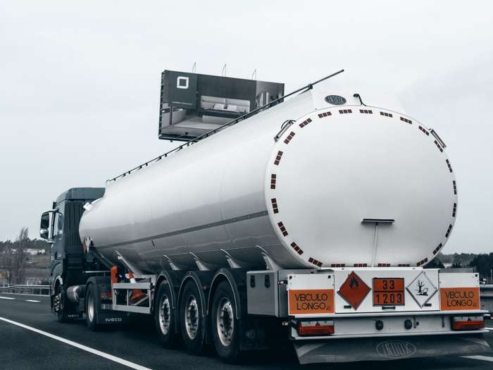 Fuel tanker with hazard placards on the road